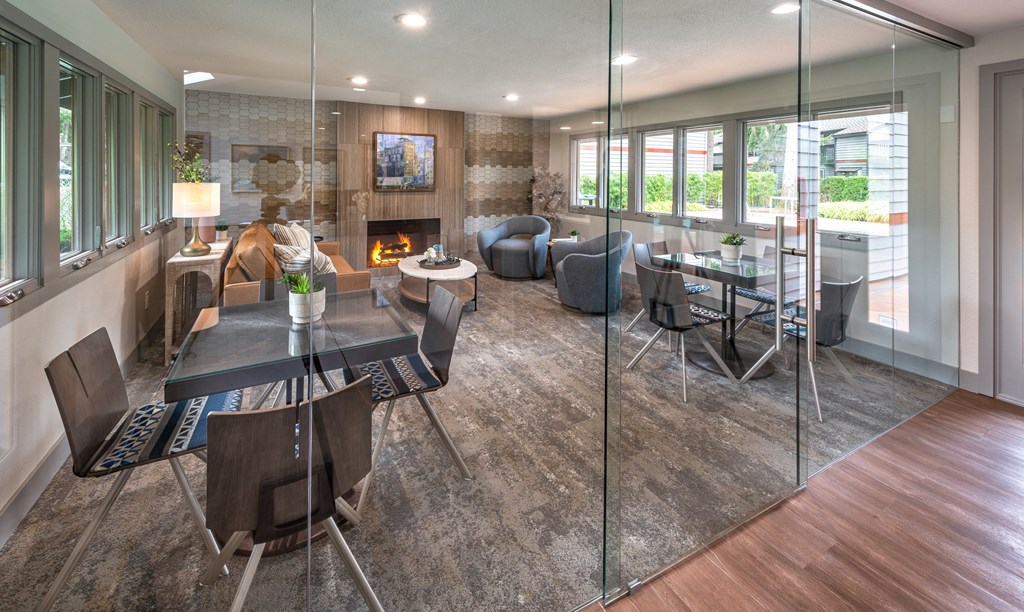 A modern dining room with a glass table and chairs.